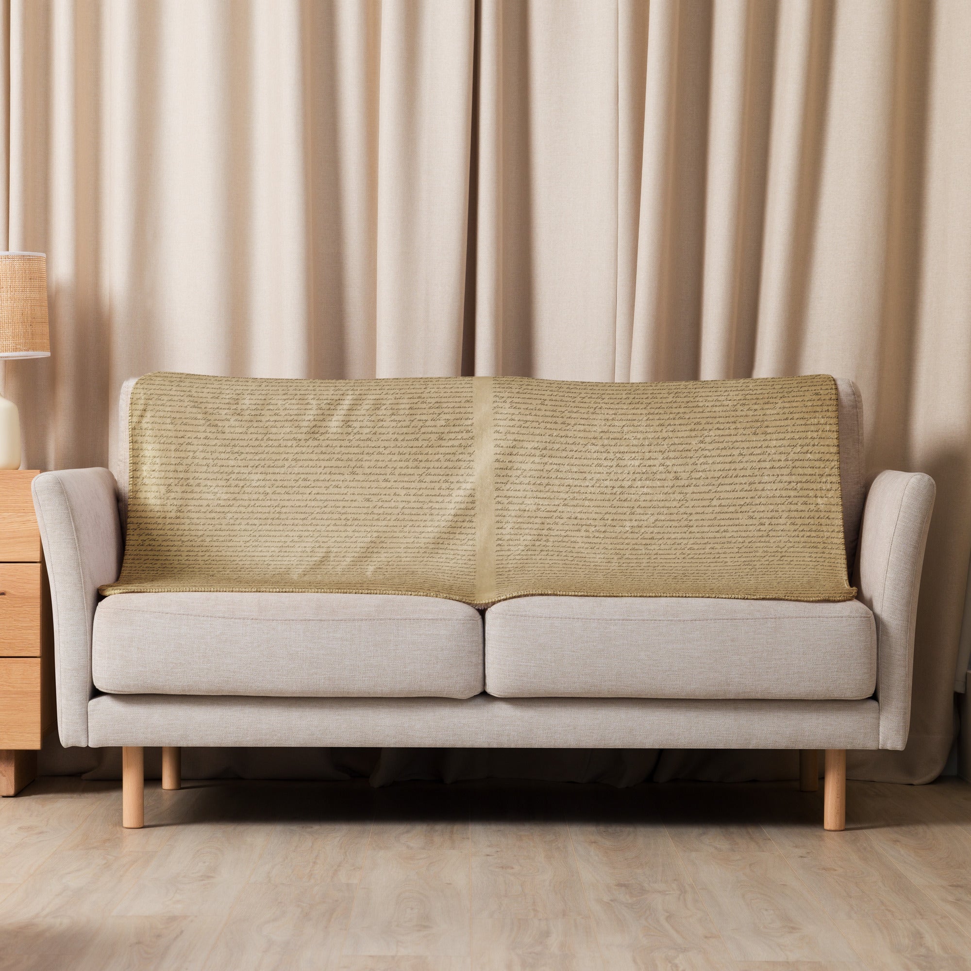Luxury Sherpa Throw Blanket in tan color draped over a modern beige sofa in a softly lit living room with matching curtains and minimalist decor.