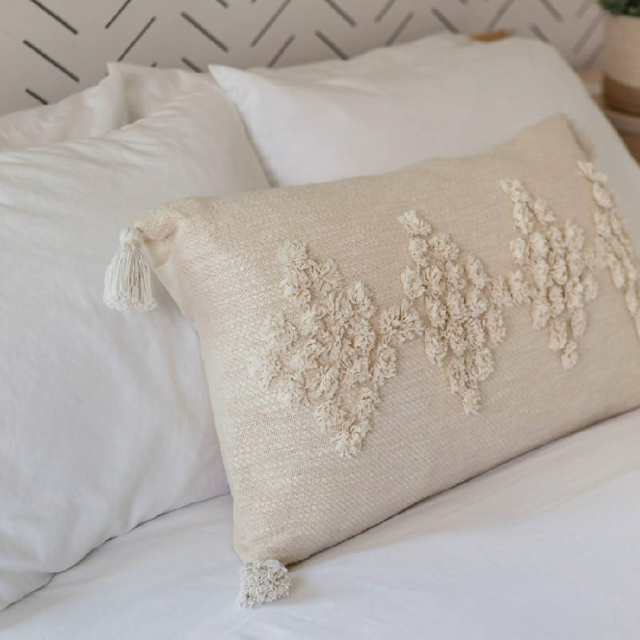 Decorative pillow with floral embroidery on a bed