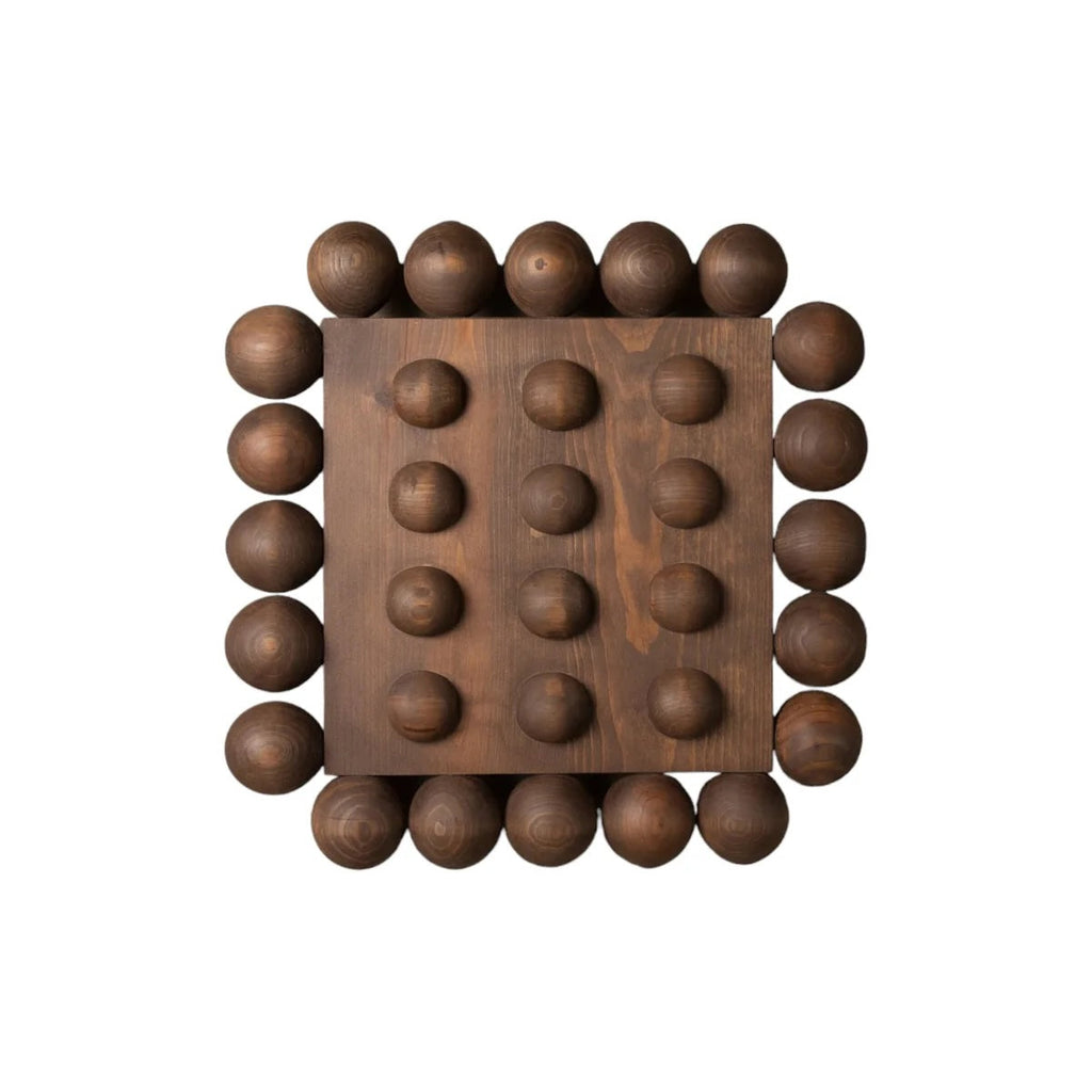 Wooden wall art piece with spherical protrusions on a white background