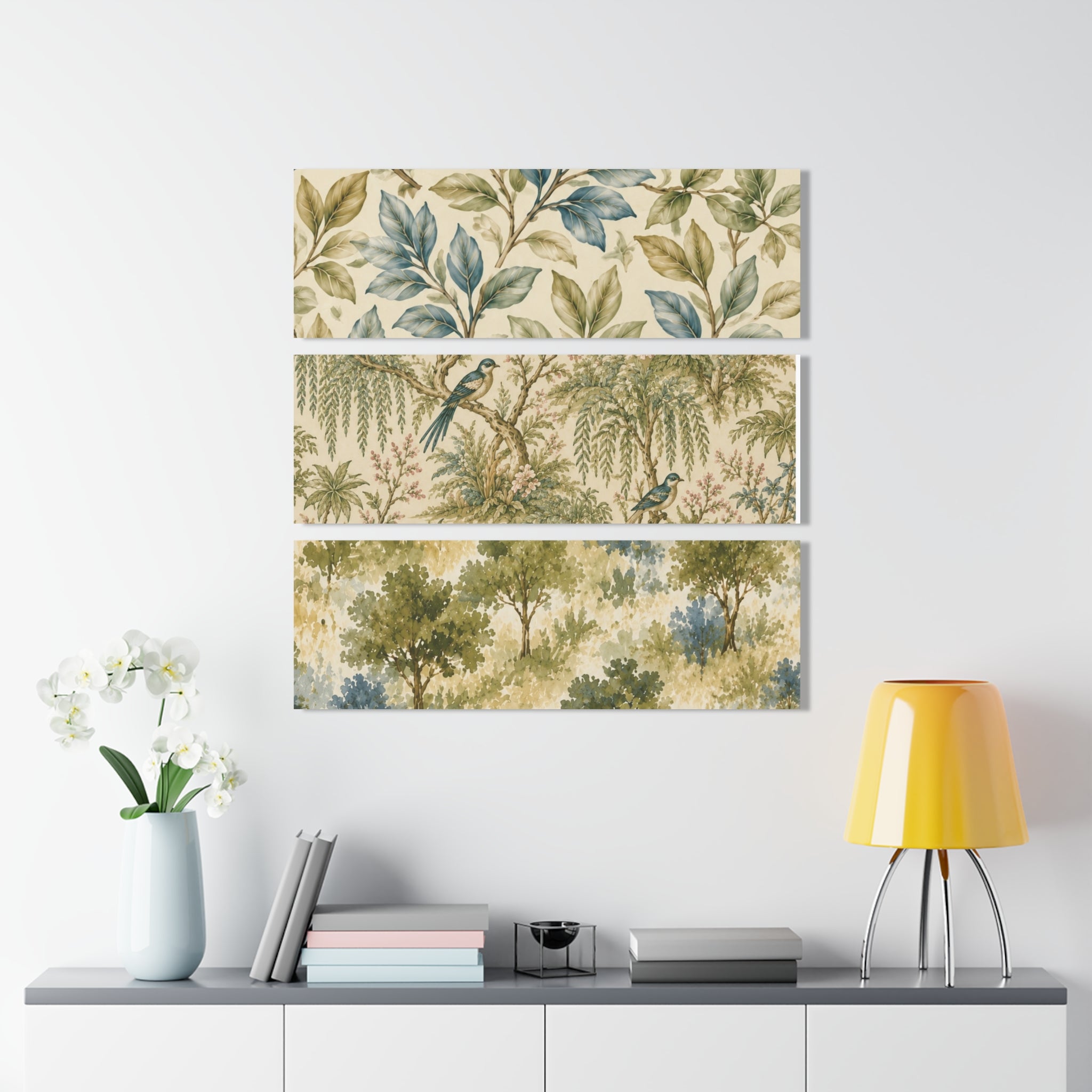 Three panel wall art with nature-themed design above a white cabinet with decorative items.