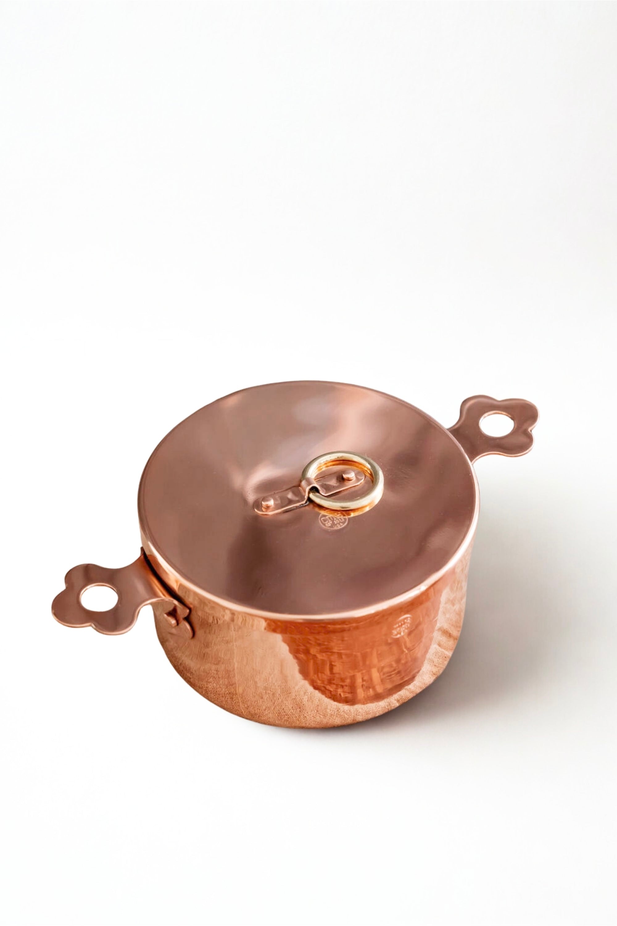 Copper pot with lid on a white background