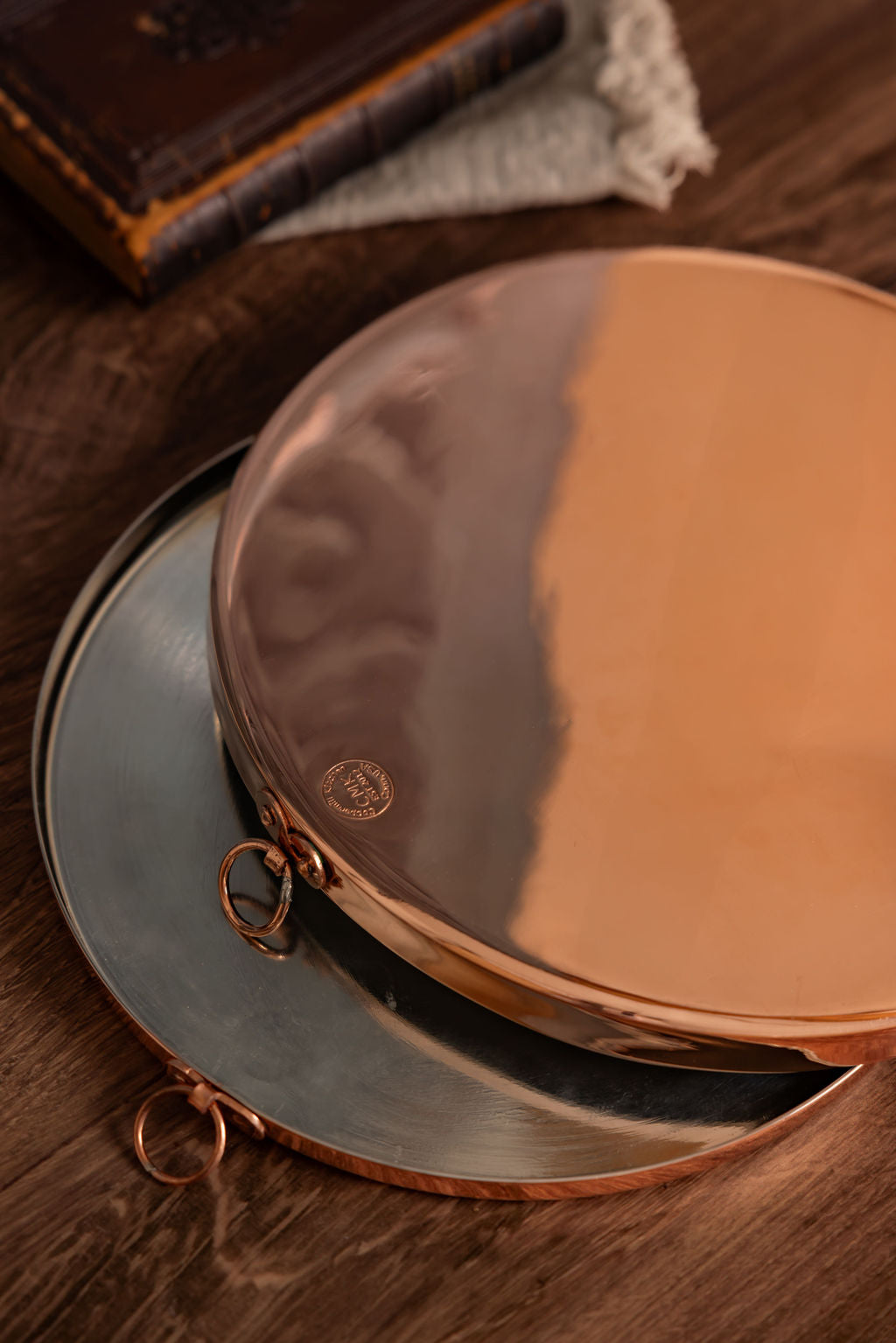 Close-up of a round, coppe pt on a wooden surface with a blurred background.