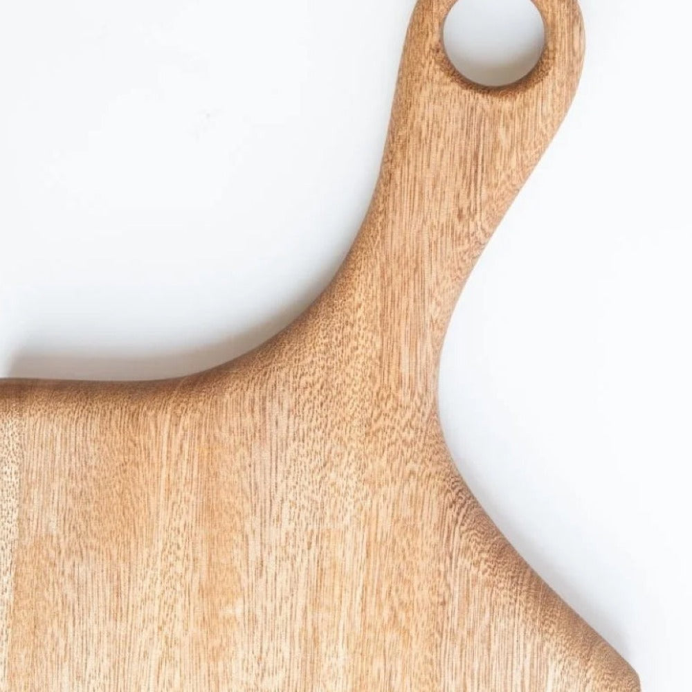 Wooden hand carved cutting board with a handle on a white background