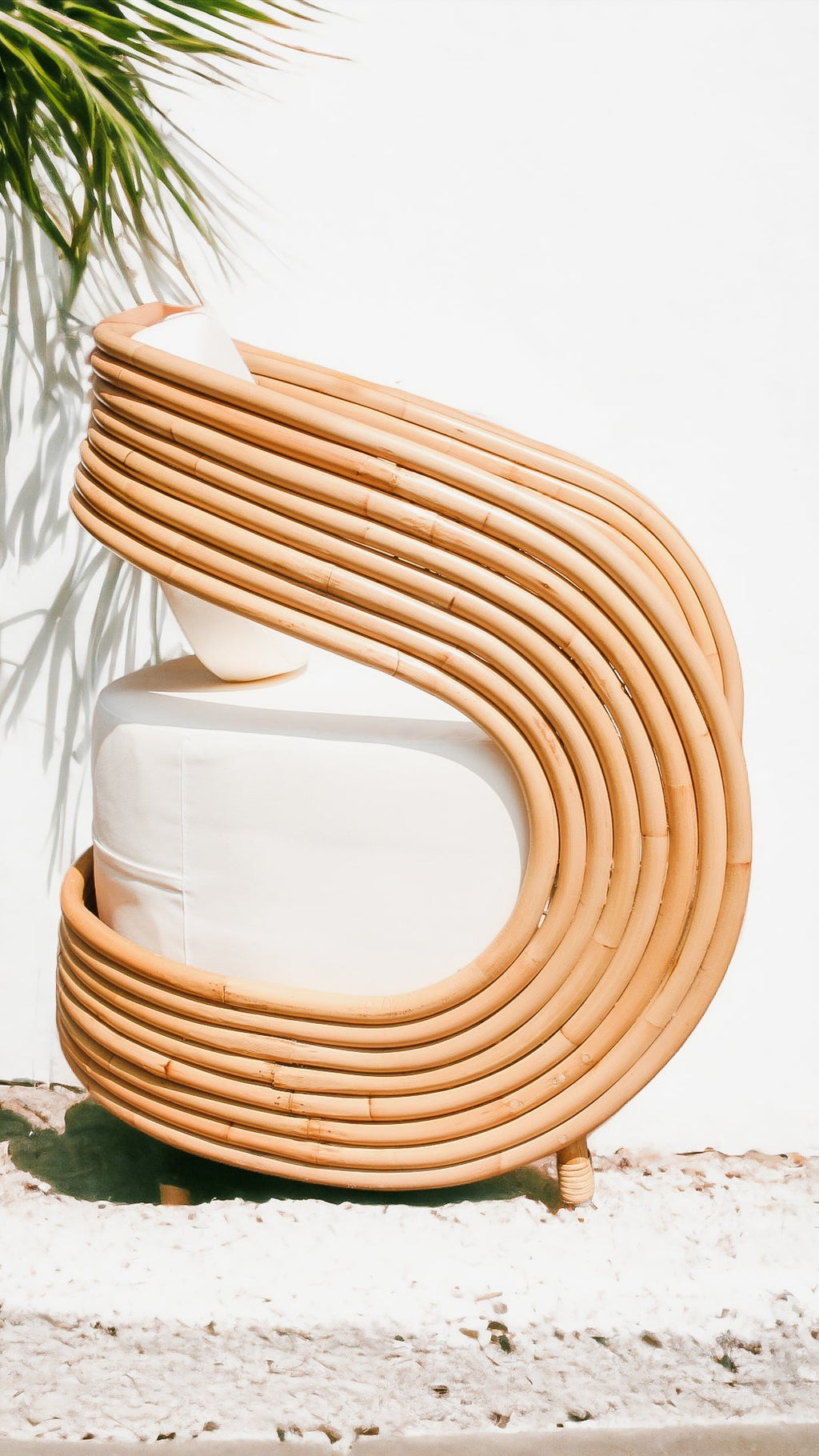 Woven chair with a white cushion on a light background