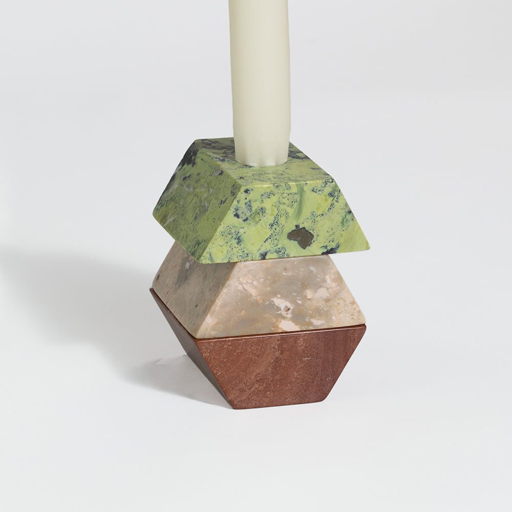 Geometric candle holder with marbled design on a white background