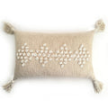 Decorative pillow with bead patterns and tassels on a white background