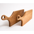 Wooden hand carved cutting board with handles on a white background