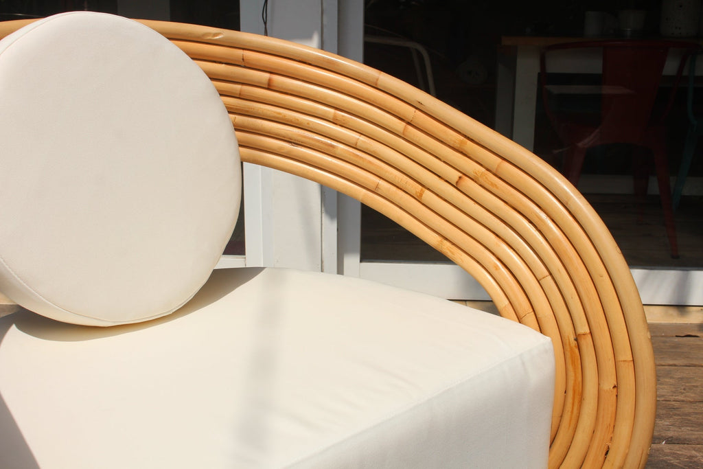 Modern outdoor furniture with curved wooden design and white cushions.