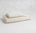Two cream-colored textured towels on a light gray background