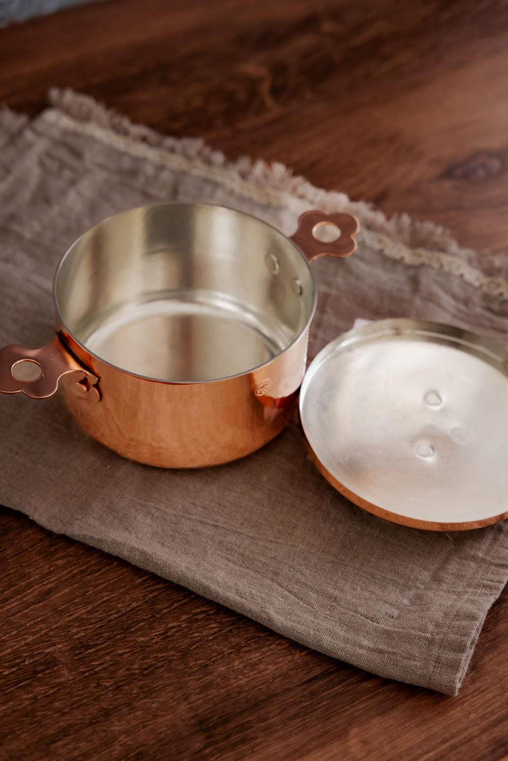 Copper pot on a wooden surface with a brown cloth underneath
