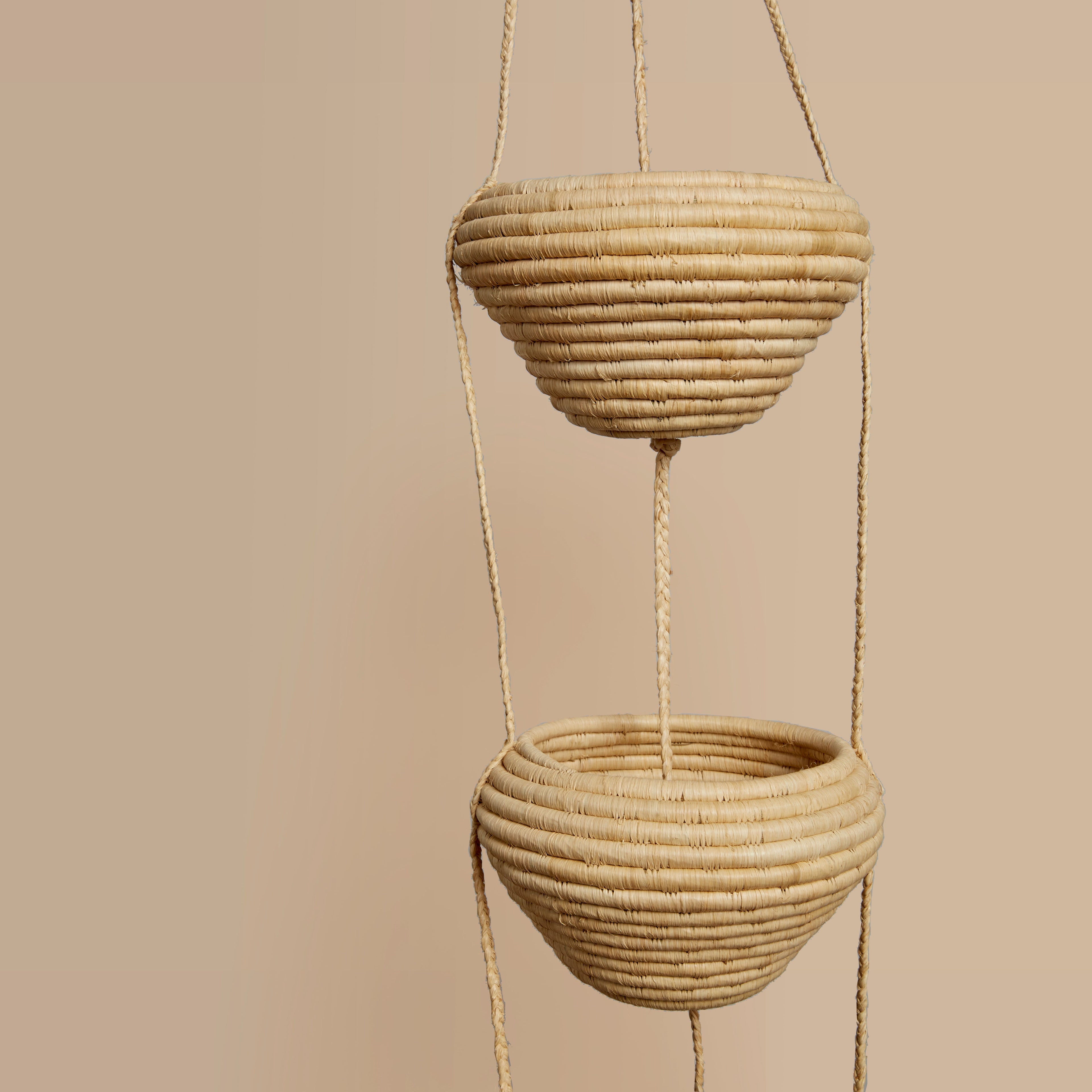 Natural 3-tiereed woven hanging planters on a beige background 
