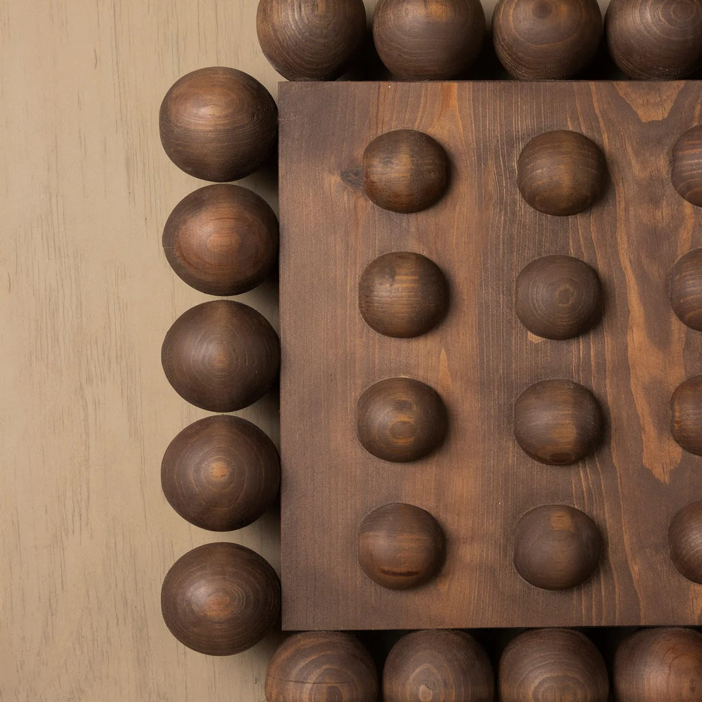 Wooden block wall art with spherical protrusions on a wooden surface