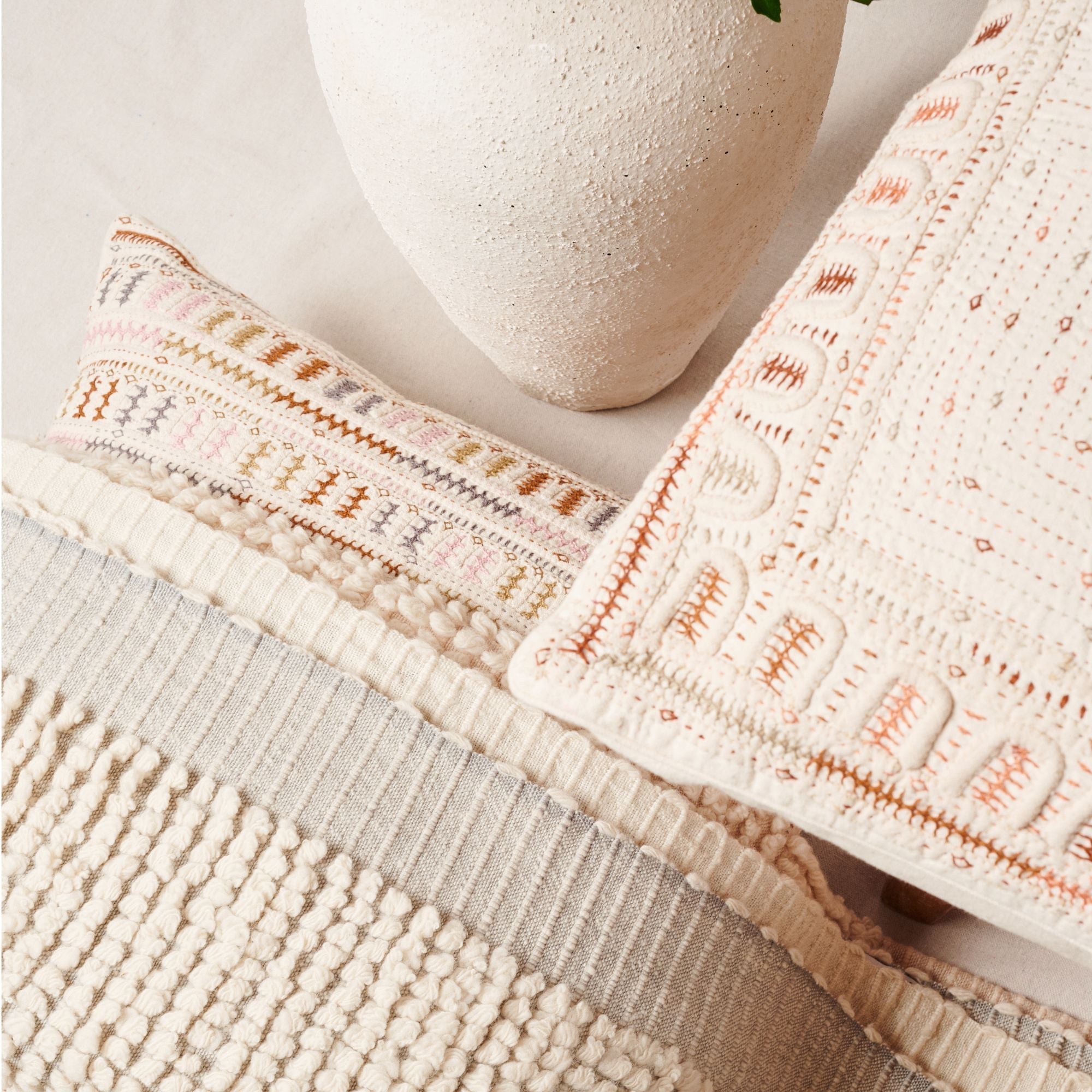 Textured pillows with geometric patterns on a neutral background