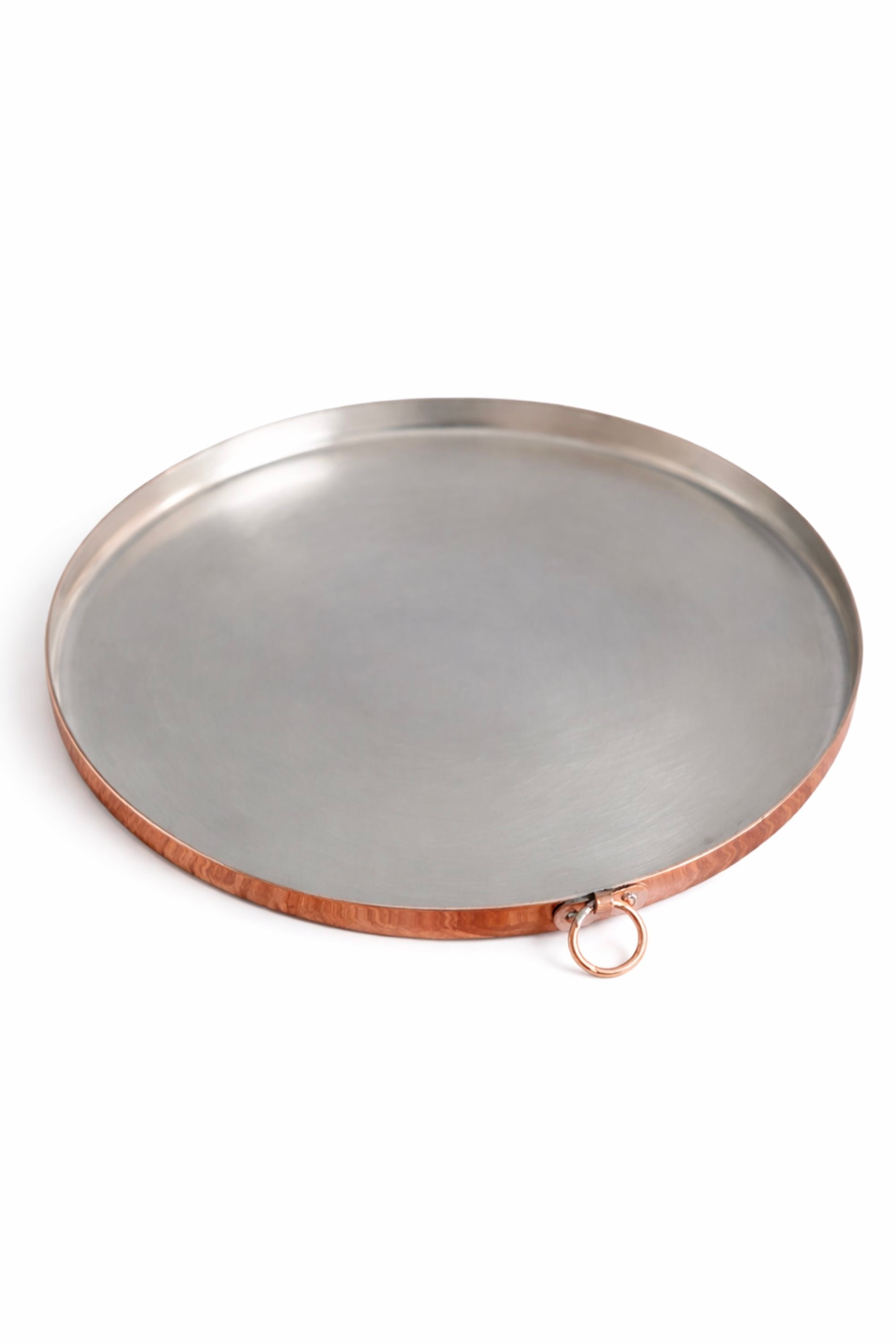 Round copper baking dish with copper rim on a white background