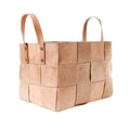 Woven beige leather basket with handles on a white background