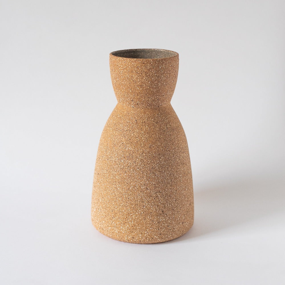 Textured brown vase on a light gray background