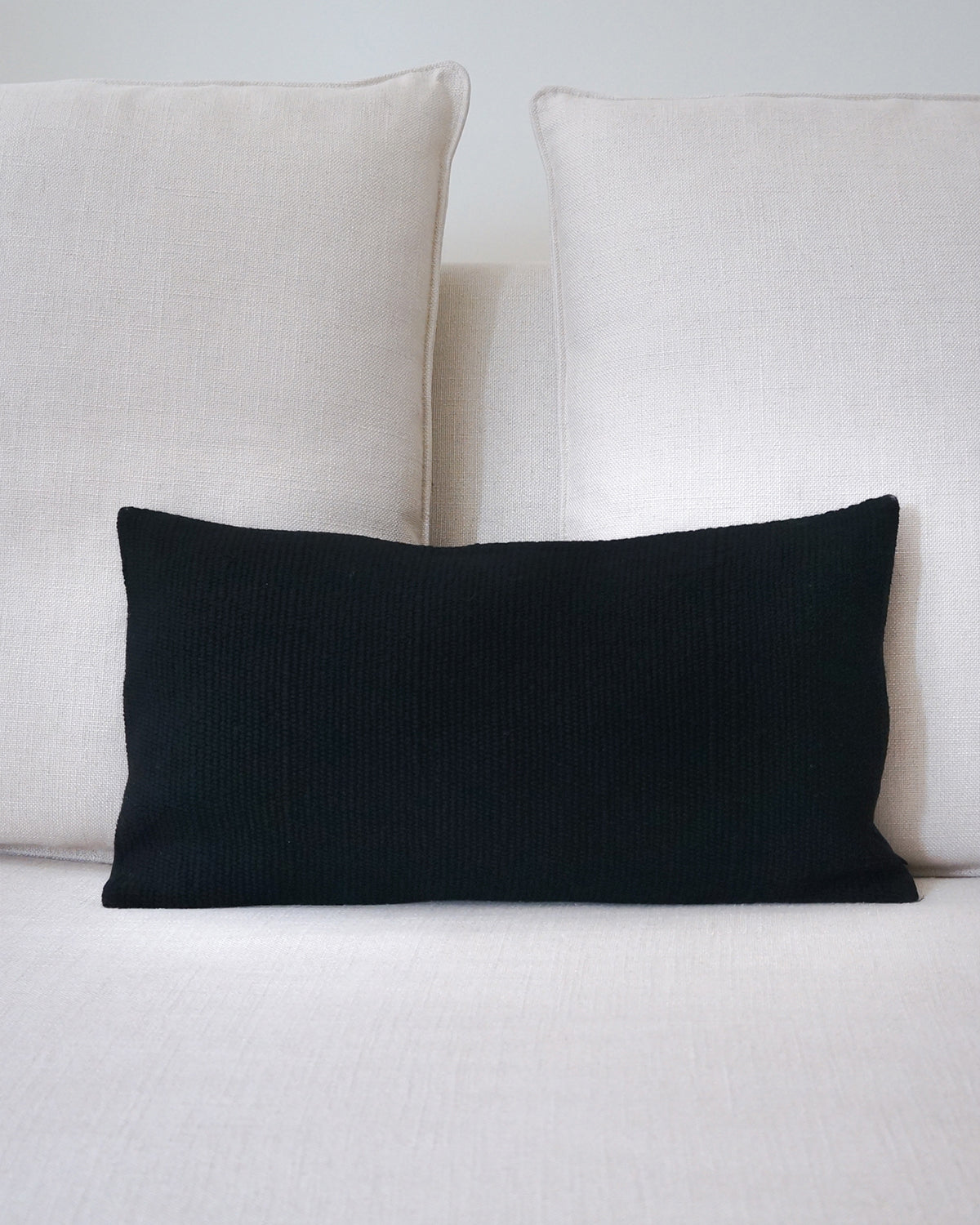 Black pillow on a light-colored sofa