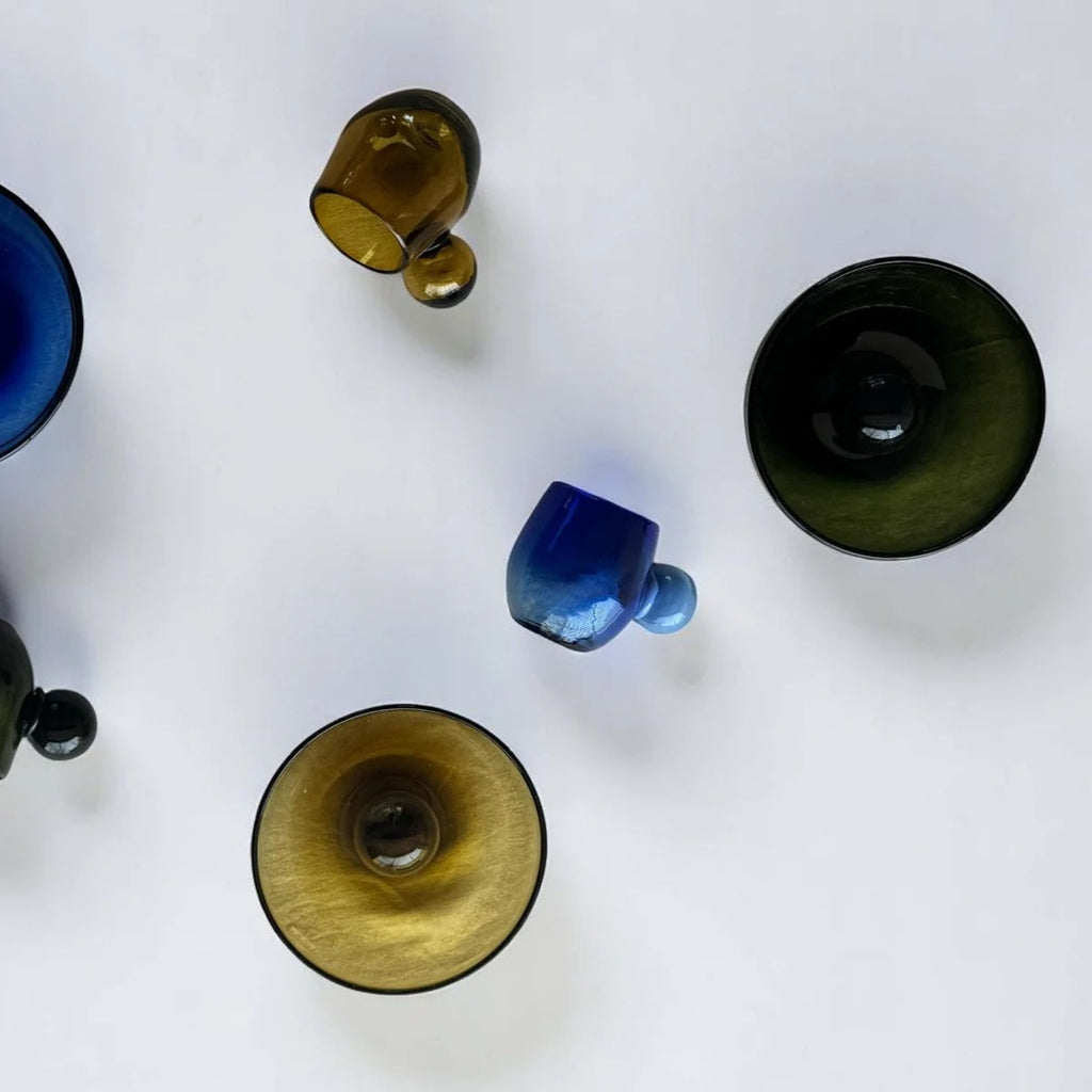 Top-down view of various glass cups/bowls on a white background