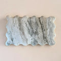 Marble Cutting Board with wavy edge on a beige background