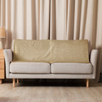 Luxury Sherpa Throw Blanket in tan color draped over a modern beige sofa in a softly lit living room with matching curtains and minimalist decor.