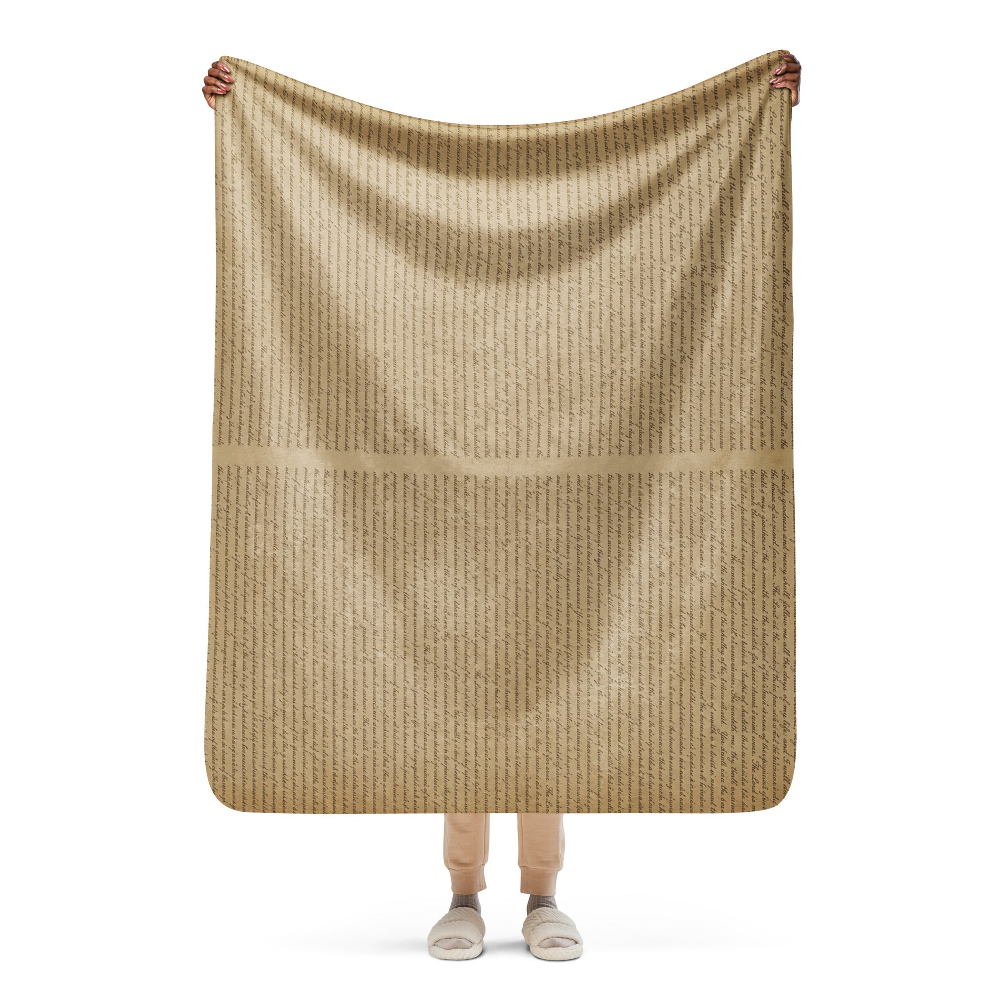 Person holding a tan Luxury Sherpa Throw Blanket with subtle vertical text patterns, showcasing its soft texture and elegant design for premium home decor.