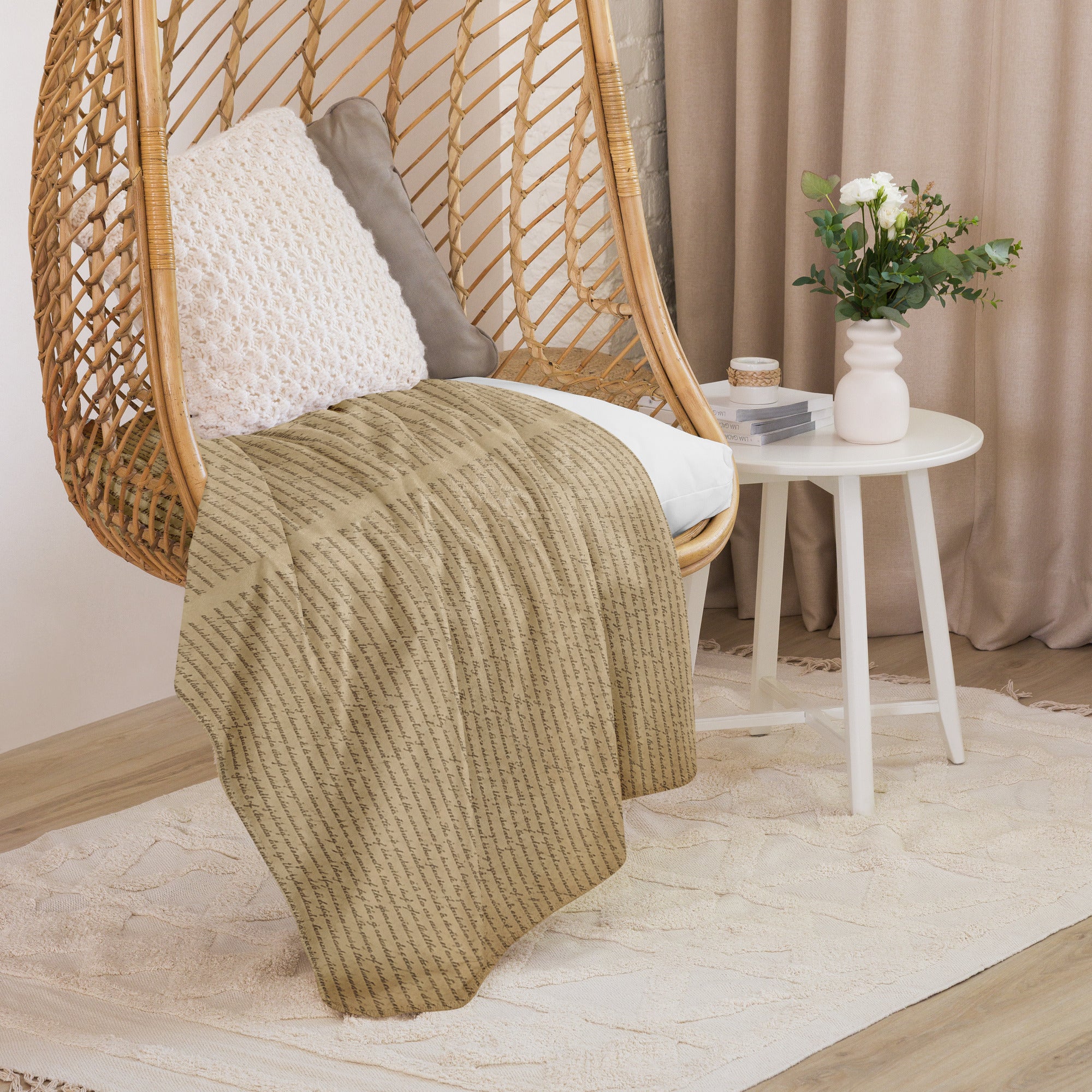 Luxury Sherpa Throw Blanket draped over a woven chair with textured cushions beside a white round table holding a vase of flowers, set in a cozy, neutral-toned room.